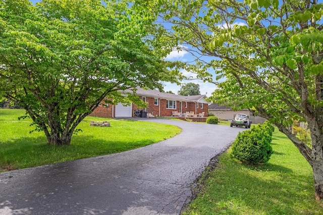 505 Kindel Dr, Decherd, TN 37324 - ranch-style house featuring brick siding, driveway, a garage, and a front yard