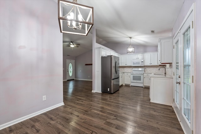kitchen featuring white appliances, vaulted ceiling, a chandelier, light countertops, and white cabinets