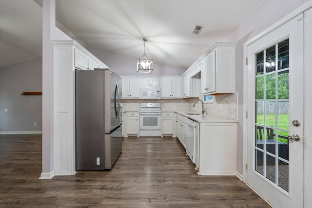 kitchen with white appliances, a sink, vaulted ceiling, backsplash, and white cabinetry