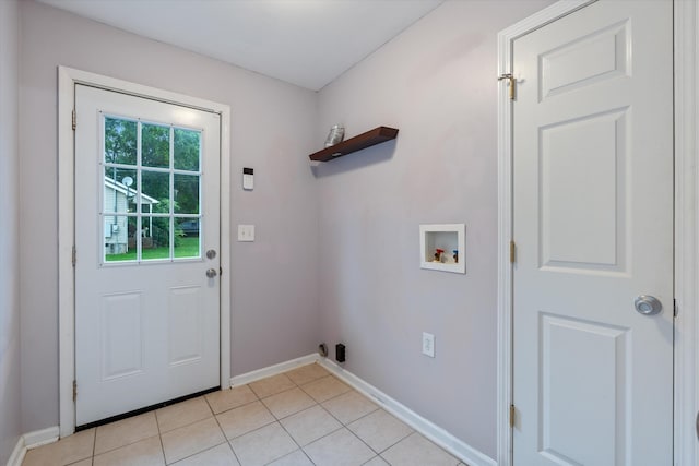 laundry room with hookup for a washing machine, baseboards, and light tile patterned floors