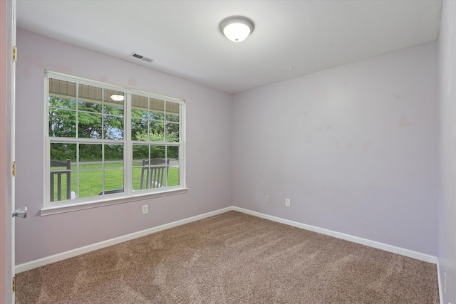 unfurnished room with carpet flooring and baseboards