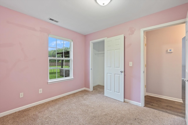 unfurnished bedroom featuring carpet, baseboards, and a closet