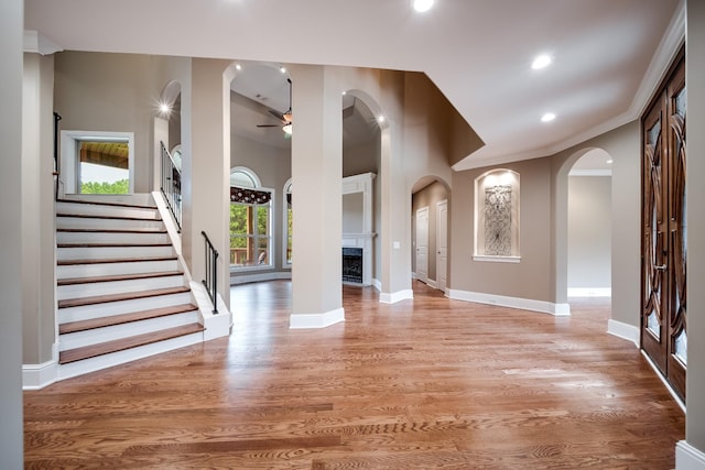 291 Bowling Branch Rd, Cottontown, TN 37048 - foyer with arched walkways, ceiling fan, a fireplace, light wood-style floors, and baseboards