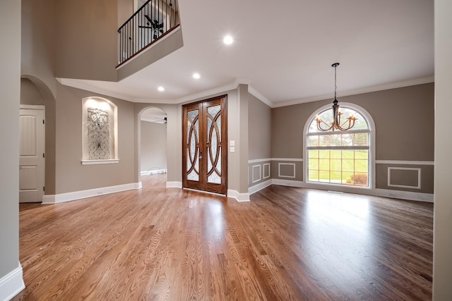 291 Bowling Branch Rd, Cottontown, TN 37048 - entryway with arched walkways, crown molding, wood finished floors, a chandelier, and wainscoting