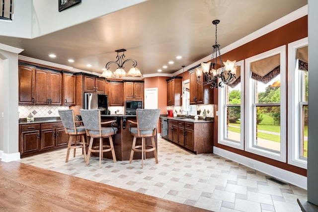 291 Bowling Branch Rd, Cottontown, TN 37048 - kitchen featuring a chandelier, dark countertops, freestanding refrigerator, crown molding, and a kitchen breakfast bar