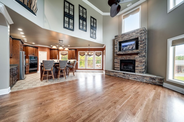 291 Bowling Branch Rd, Cottontown, TN 37048 - living area with a fireplace, crown molding, a chandelier, a high ceiling, and plenty of natural light