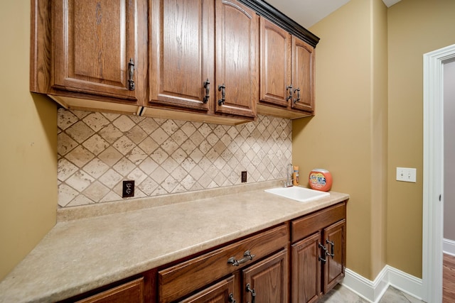 291 Bowling Branch Rd, Cottontown, TN 37048 - kitchen with a sink, backsplash, light countertops, baseboards, and brown cabinets