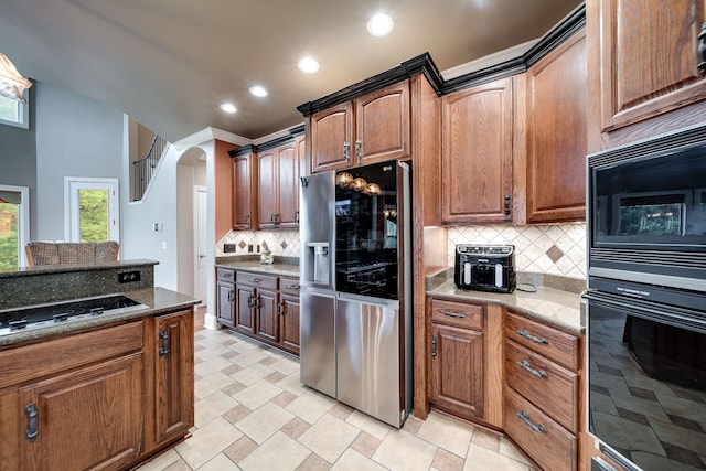 291 Bowling Branch Rd, Cottontown, TN 37048 - kitchen featuring black appliances, tasteful backsplash, dark stone countertops, recessed lighting, and arched walkways