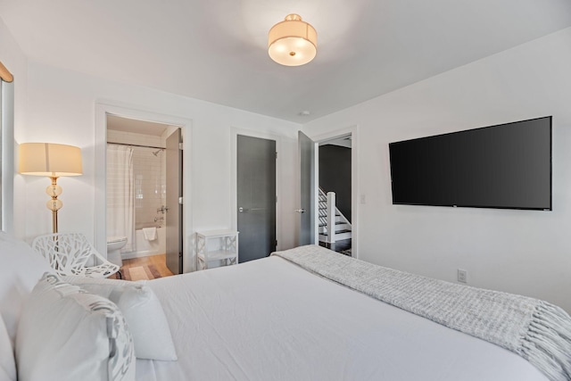 bedroom featuring ensuite bathroom and wood finished floors