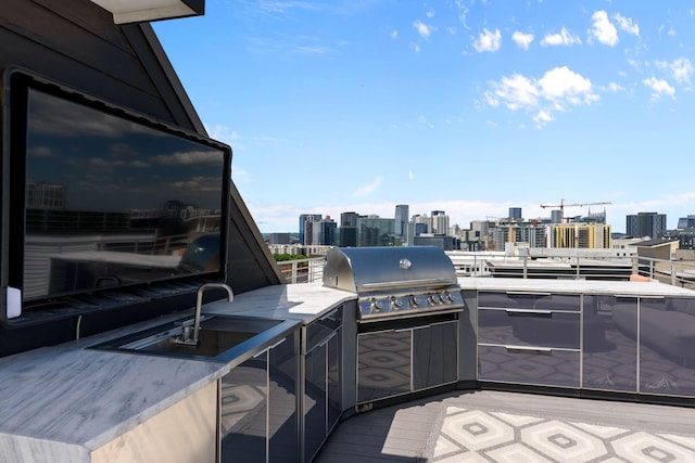 view of patio / terrace with a grill, exterior kitchen, a city view, and a sink