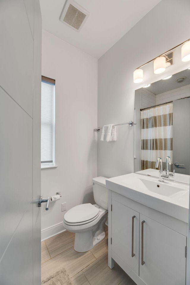 bathroom featuring toilet, vanity, wood finished floors, a shower with shower curtain, and baseboards