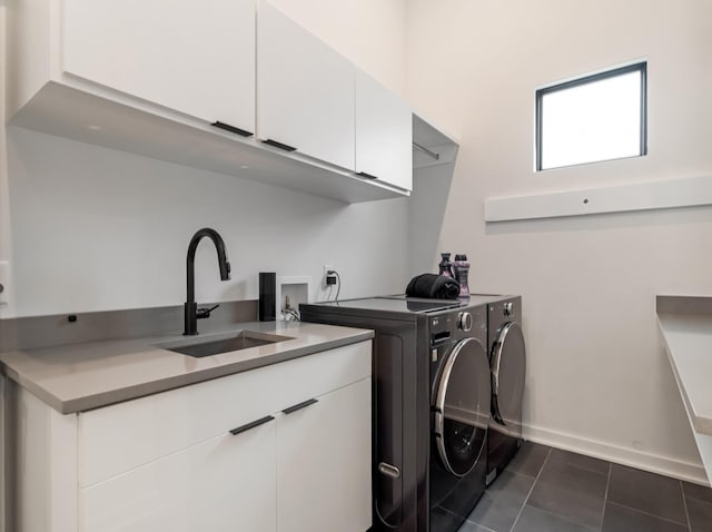 washroom with washer and dryer, cabinet space, dark tile patterned floors, and baseboards
