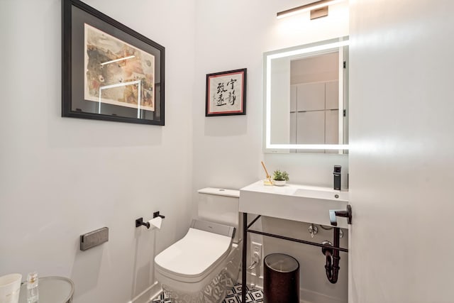 bathroom with toilet and baseboards