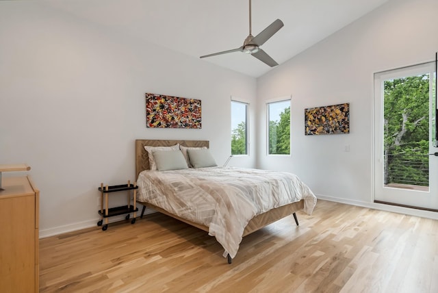 bedroom featuring multiple windows, light wood finished floors, access to outside, high vaulted ceiling, and baseboards