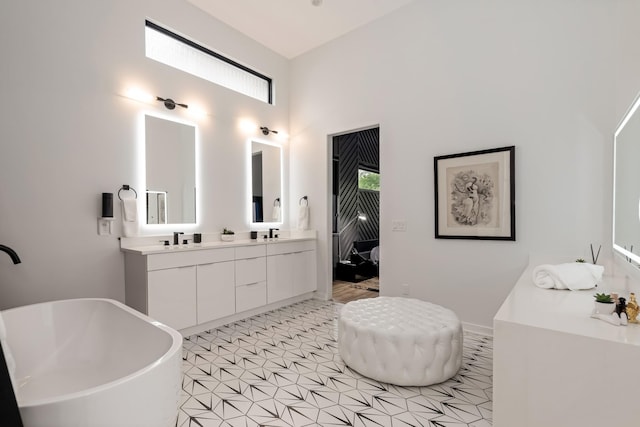 full bathroom featuring a soaking tub, double vanity, and a high ceiling