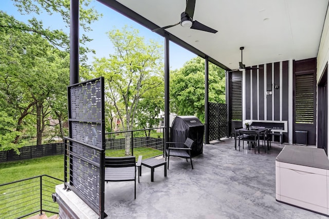 view of patio / terrace featuring ceiling fan, a grill, and view of wooded area