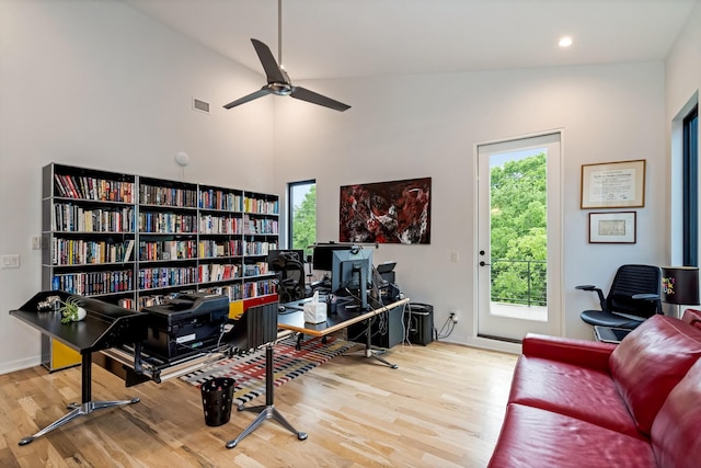 home office featuring wood finished floors, ceiling fan, a towering ceiling, recessed lighting, and baseboards