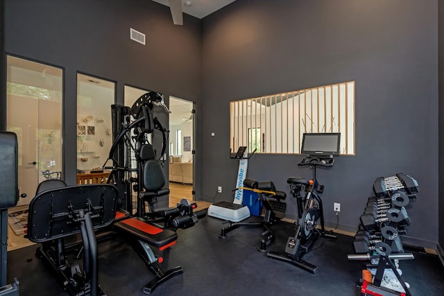 gym featuring a towering ceiling