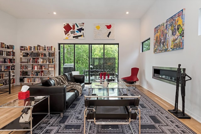living room featuring plenty of natural light, wood finished floors, recessed lighting, and baseboards