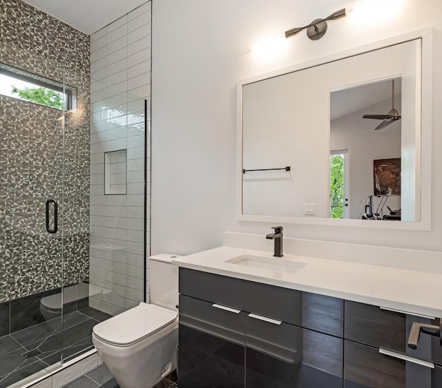 bathroom with toilet, a stall shower, vanity, and a ceiling fan