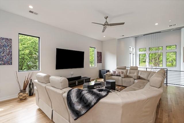 living room featuring light wood-type flooring, a ceiling fan, recessed lighting, and baseboards