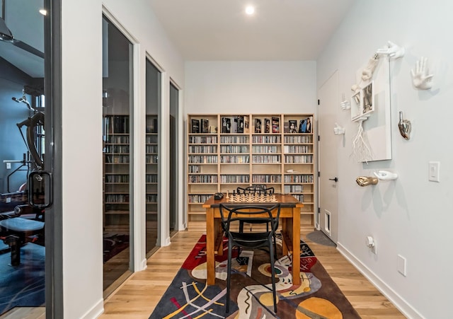 dining space featuring light wood finished floors and baseboards