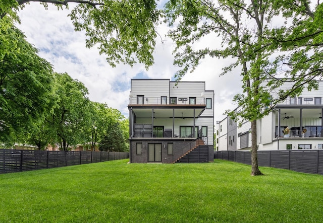 back of property with a ceiling fan, stairs, and a balcony