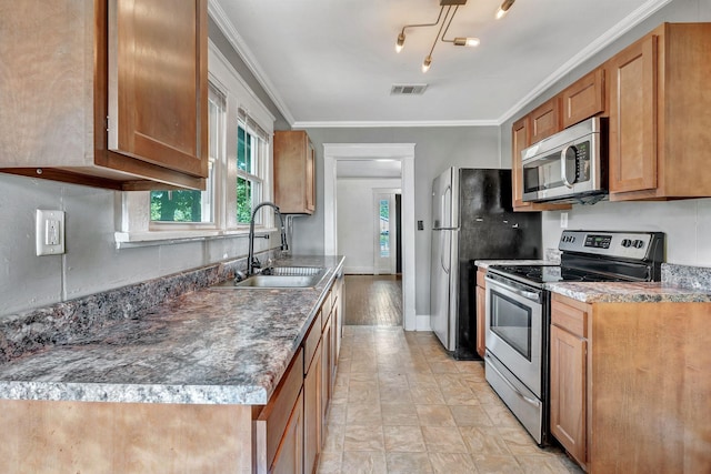 kitchen featuring stainless steel appliances, a sink, crown molding, and brown cabinetry