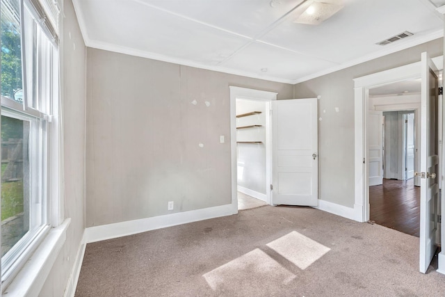 unfurnished bedroom with carpet, multiple windows, crown molding, and baseboards
