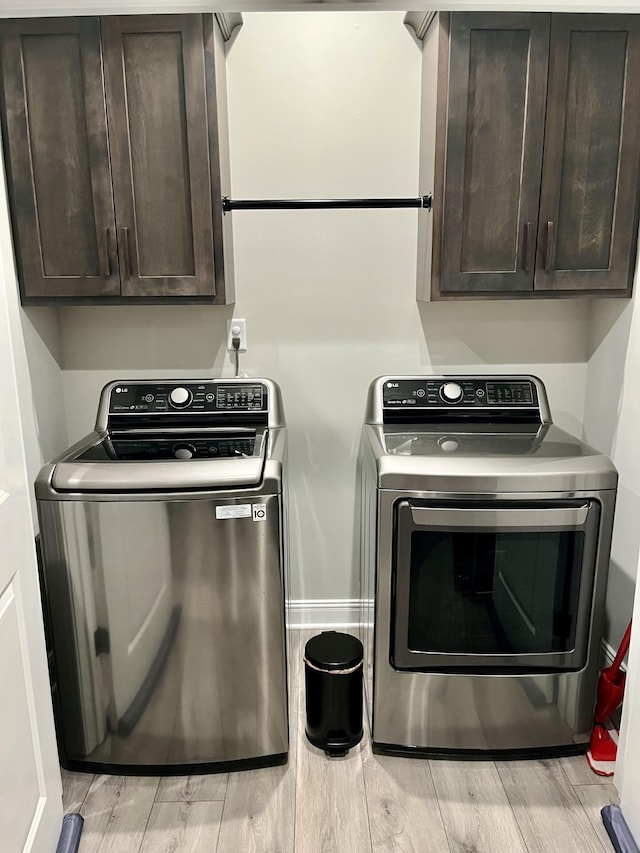 2063 Rylee Way, Greenbrier, TN 37073 - laundry area featuring cabinet space, washer and clothes dryer, and light wood-style flooring