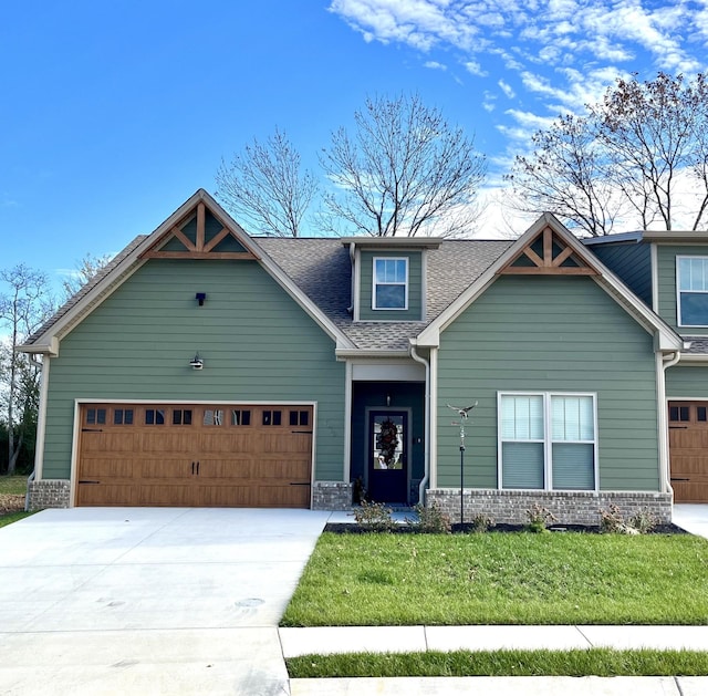 2063 Rylee Way, Greenbrier, TN 37073 - craftsman-style house featuring a front lawn, a garage, concrete driveway, a shingled roof, and stone siding