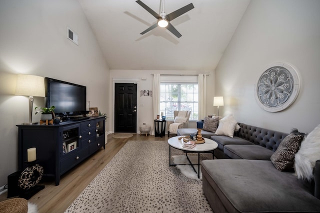 living area featuring high vaulted ceiling, light wood-style flooring, and a ceiling fan
