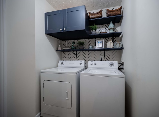 laundry area with cabinet space, independent washer and dryer, and a textured ceiling