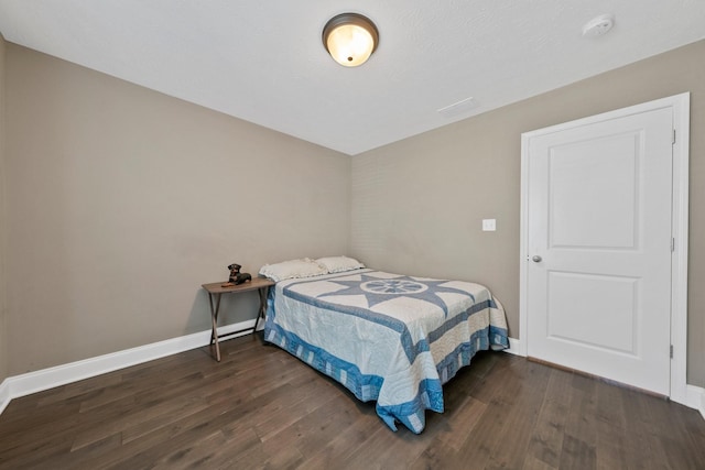 bedroom featuring dark wood-type flooring and baseboards