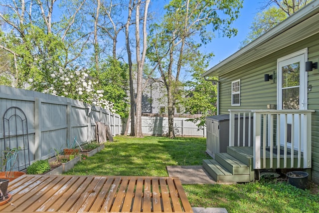 view of yard featuring a wooden deck and a vegetable garden