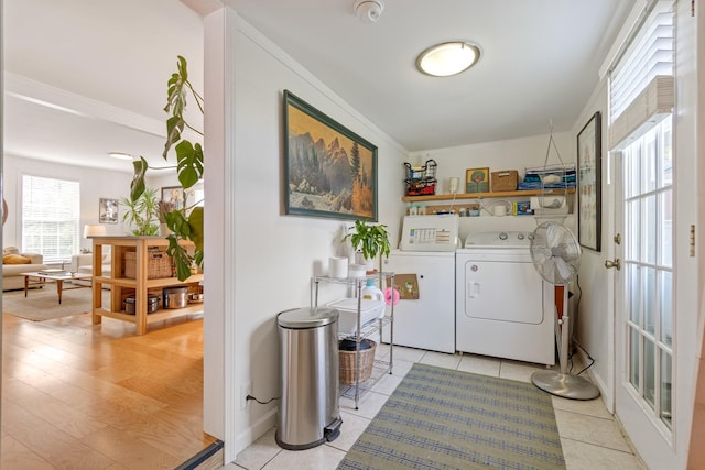 laundry room featuring washer and clothes dryer, crown molding, and light tile patterned floors