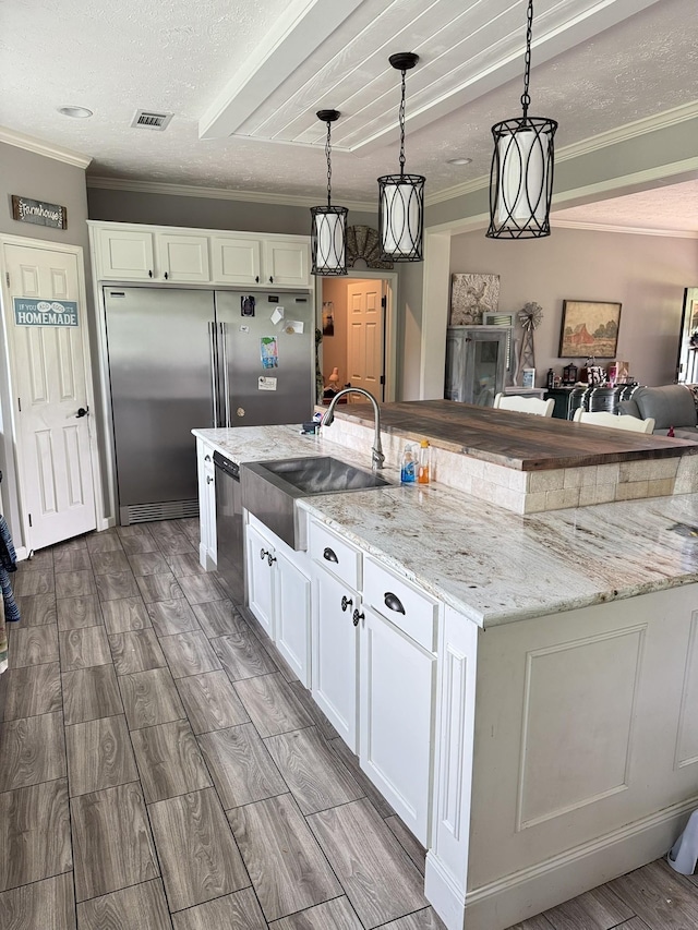 287 Sisk Rd, Winchester, TN 37398 - kitchen with a sink, stainless steel appliances, crown molding, white cabinetry, and wood finish floors