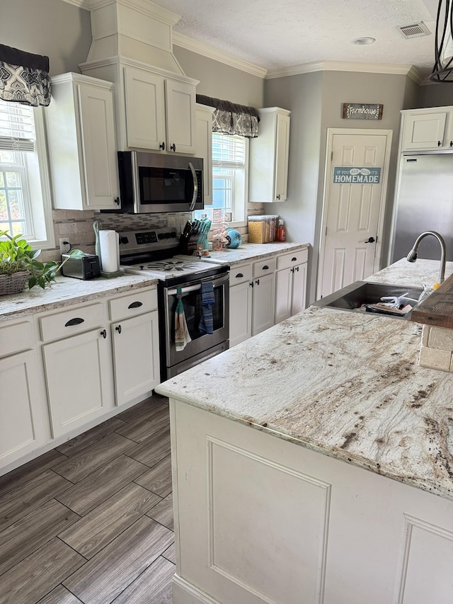 287 Sisk Rd, Winchester, TN 37398 - kitchen with appliances with stainless steel finishes, ornamental molding, a sink, white cabinetry, and decorative backsplash