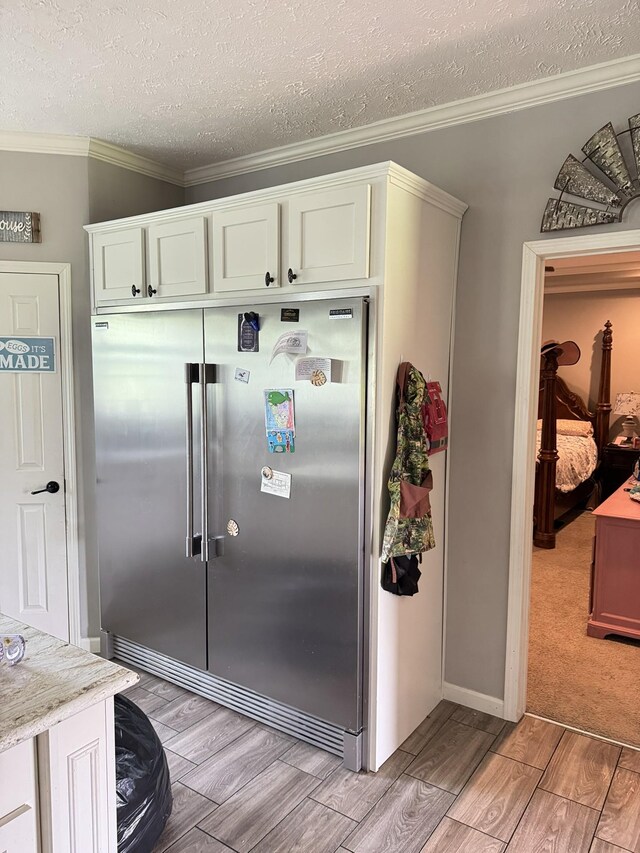 287 Sisk Rd, Winchester, TN 37398 - kitchen with stainless steel built in refrigerator, wood finish floors, a textured ceiling, ornamental molding, and white cabinetry