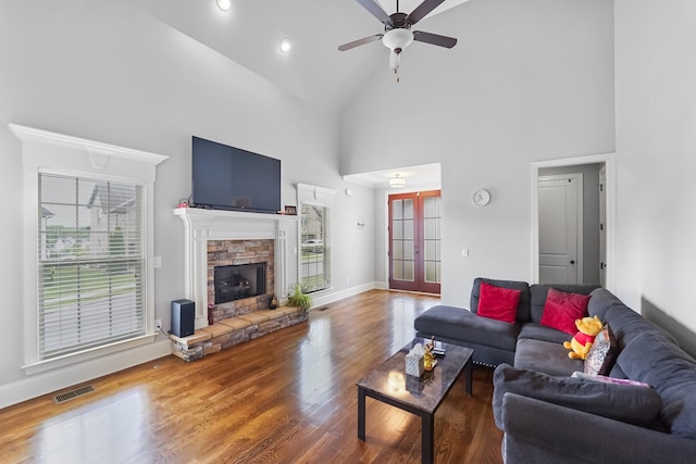living room with plenty of natural light, french doors, a ceiling fan, wood finished floors, and high vaulted ceiling
