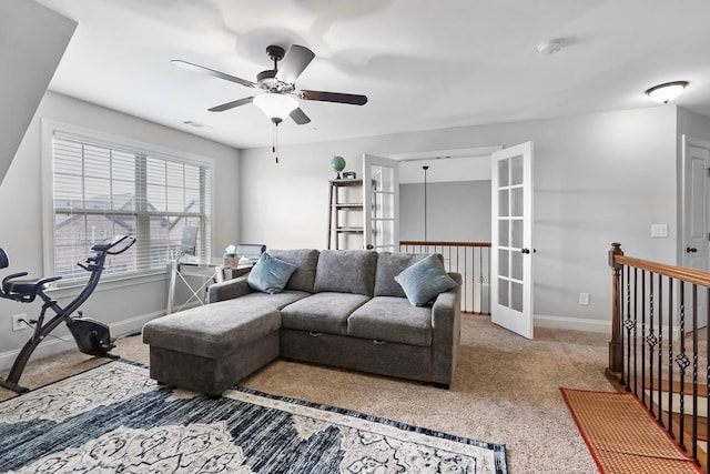 carpeted living area with french doors, baseboards, and a ceiling fan