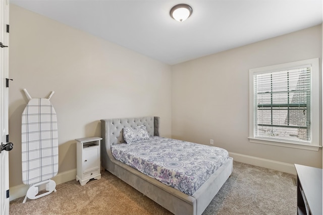 bedroom featuring light carpet and baseboards