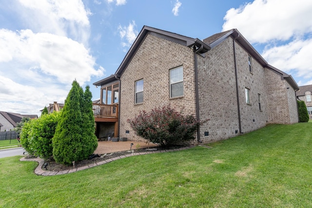 back of property with a lawn, brick siding, crawl space, and a wooden deck