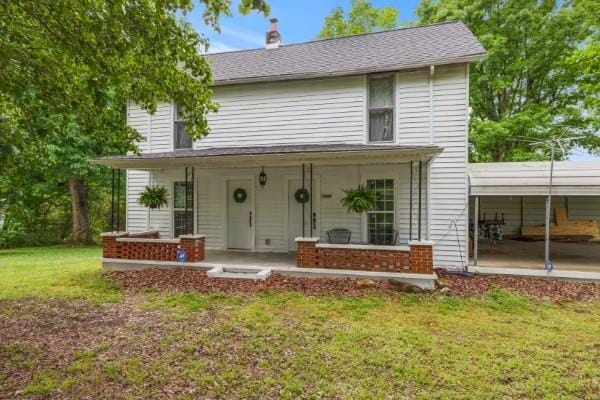 view of front facade with a front yard and covered porch