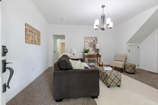 living area featuring carpet and a chandelier