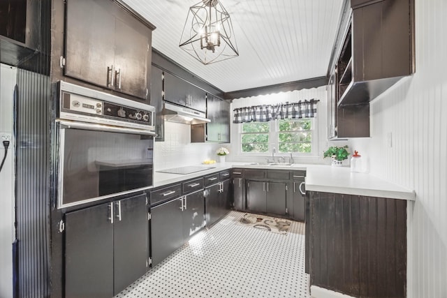 1885 N Soules Chapel Rd, Cunningham, TN 37052 - kitchen featuring wall oven, black electric cooktop, under cabinet range hood, a chandelier, and light countertops