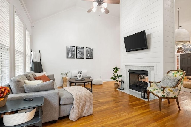 2184 Loudenslager Dr, Thompsons Station, TN 37179 - living area featuring ceiling fan, light wood finished floors, crown molding, a fireplace with flush hearth, and high vaulted ceiling