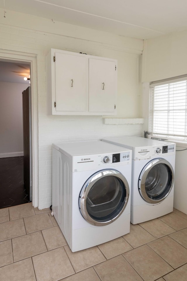 2219 Blair Blvd, Nashville, TN 37212 - clothes washing area with washer and clothes dryer, cabinet space, and light tile patterned floors