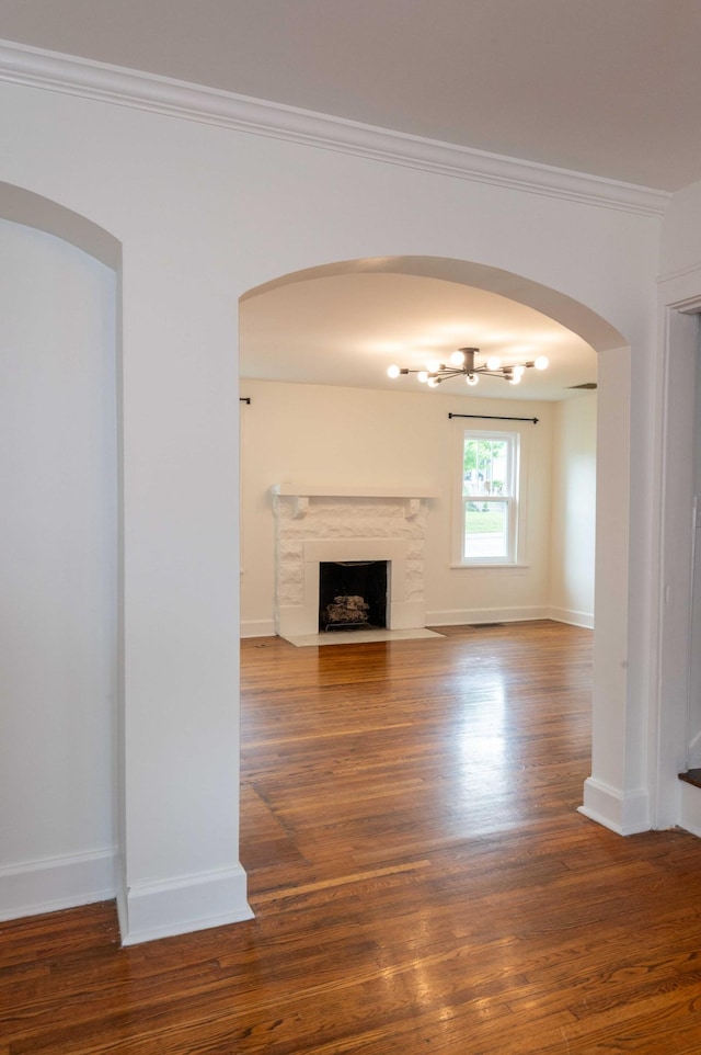 2219 Blair Blvd, Nashville, TN 37212 - unfurnished living room featuring wood finished floors, crown molding, a high end fireplace, baseboards, and arched walkways