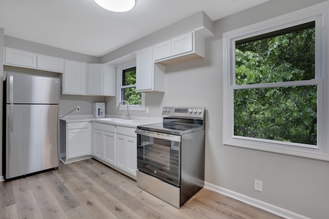 1454 Elm Hill Dr, Clarksville, TN 37040 - kitchen with appliances with stainless steel finishes, a sink, light countertops, white cabinets, and light wood finished floors